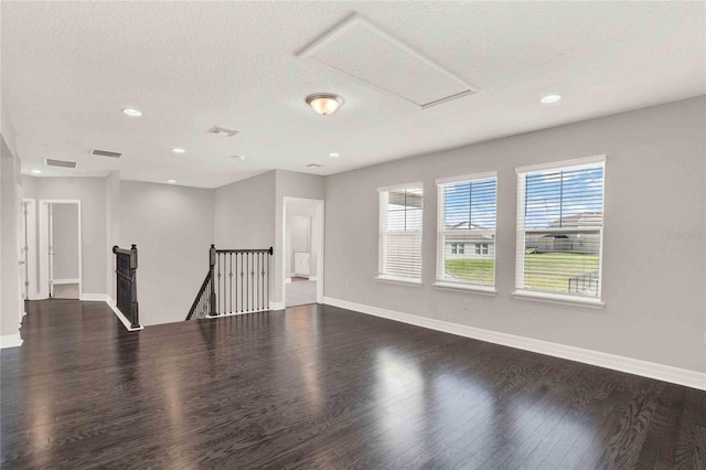 spare room with dark wood-type flooring and a textured ceiling