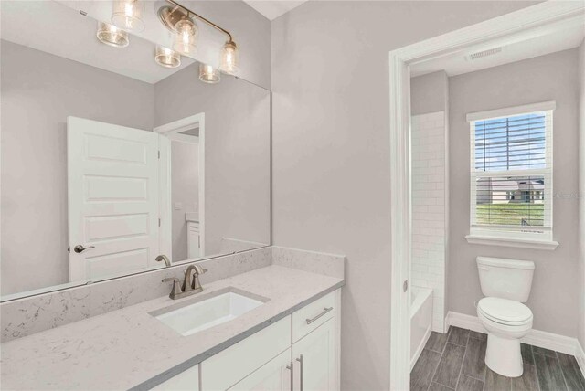 full bathroom featuring vanity, toilet, and tiled shower / bath combo