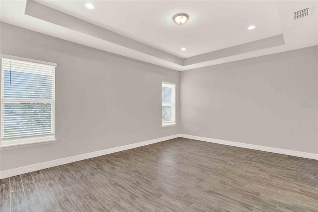 spare room featuring hardwood / wood-style floors and a tray ceiling