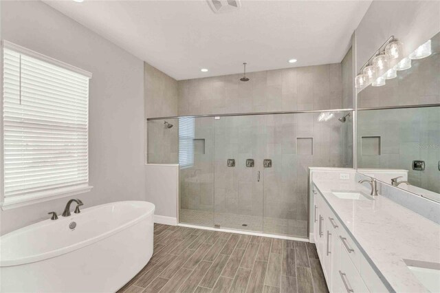 bathroom with vanity and shower with separate bathtub