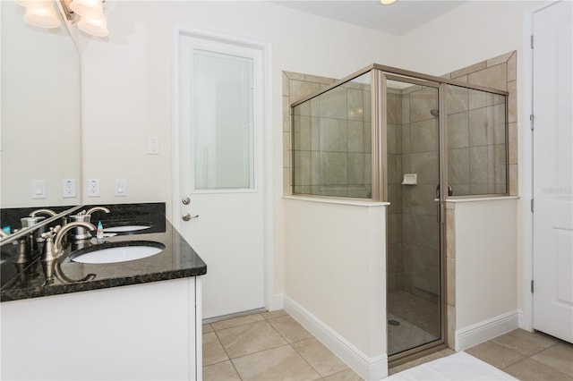 bathroom featuring dual bowl vanity, tile flooring, and walk in shower