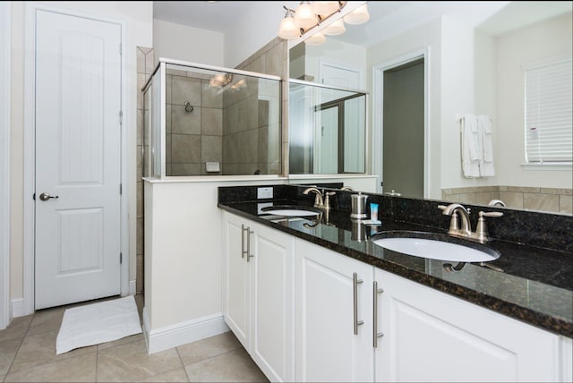 bathroom with large vanity, tile flooring, double sink, and walk in shower