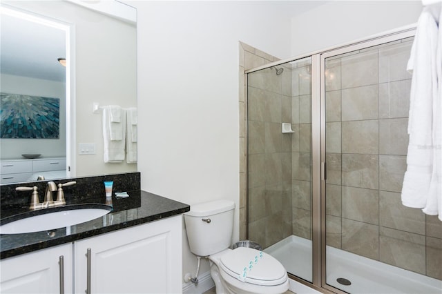 bathroom with toilet, large vanity, and a shower with shower door