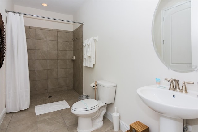 bathroom with sink, curtained shower, tile floors, and toilet