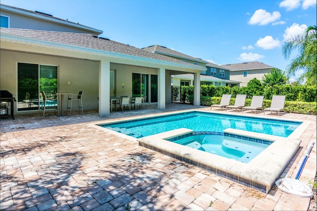 view of swimming pool with an in ground hot tub and a patio