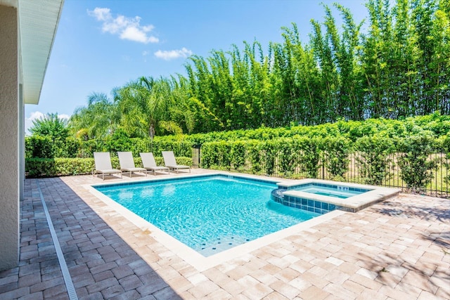 view of swimming pool featuring a patio and an in ground hot tub