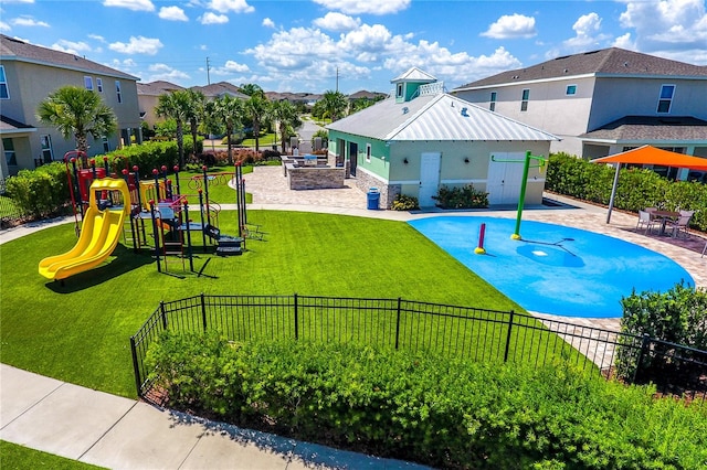 view of pool featuring a playground, a patio, an outdoor kitchen, and a yard