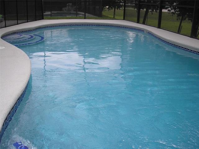 view of pool with glass enclosure