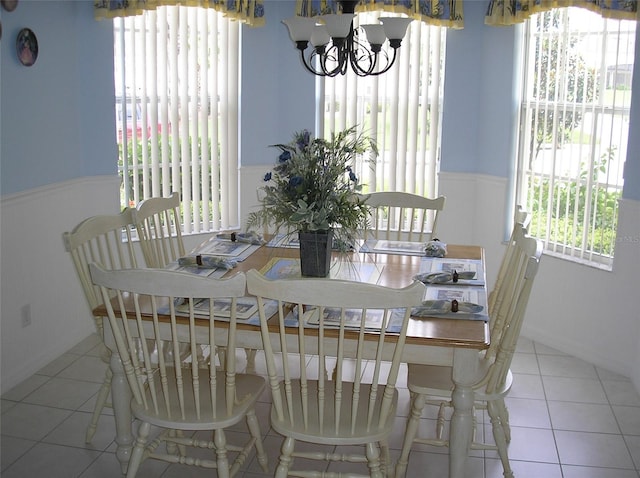 dining space with a notable chandelier and light tile floors