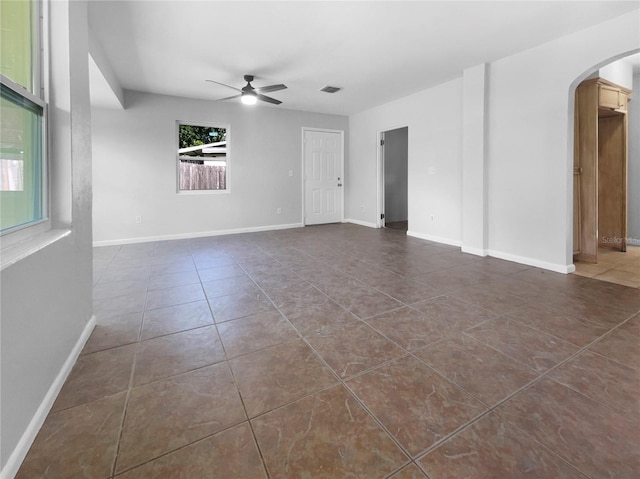 tiled spare room with ceiling fan