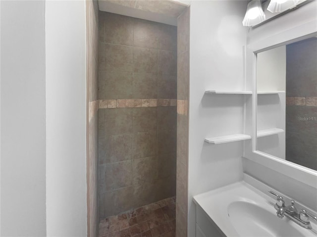 bathroom featuring a tile shower and vanity