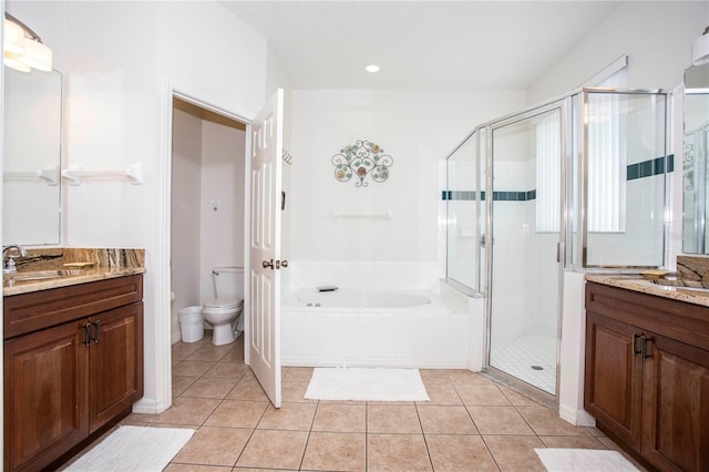 bathroom with a stall shower, a garden tub, toilet, and tile patterned floors