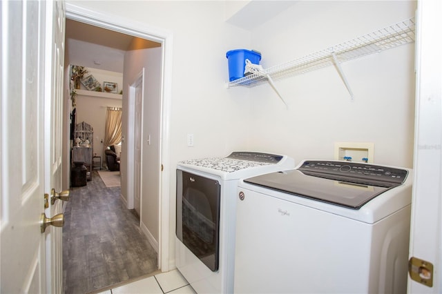 laundry area with laundry area, light tile patterned floors, and washing machine and clothes dryer