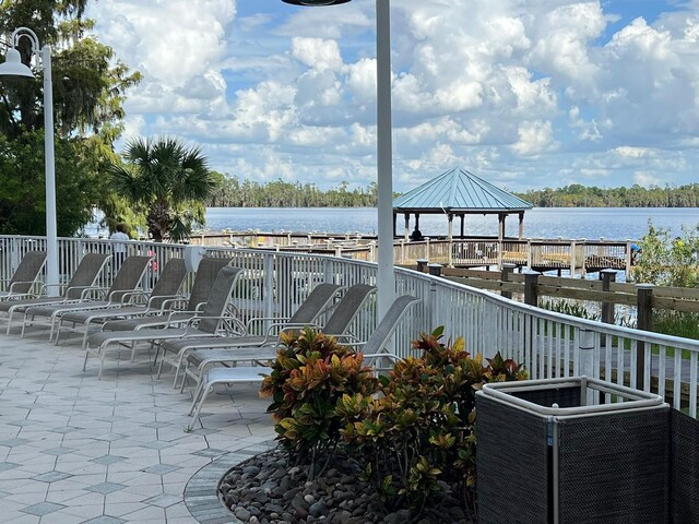 view of patio featuring a gazebo, central AC, and a water view