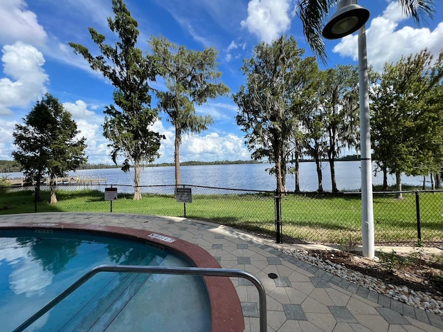 view of swimming pool with a lawn and a water view