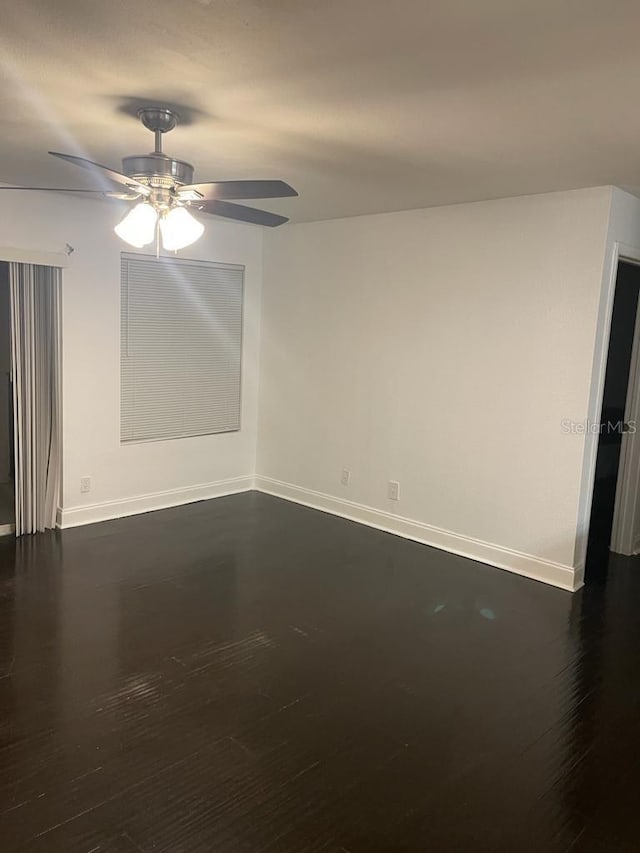 empty room with dark hardwood / wood-style flooring and ceiling fan