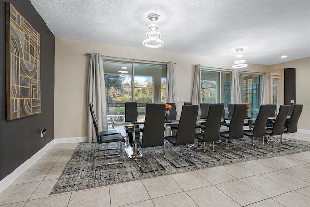 tiled dining room featuring a textured ceiling