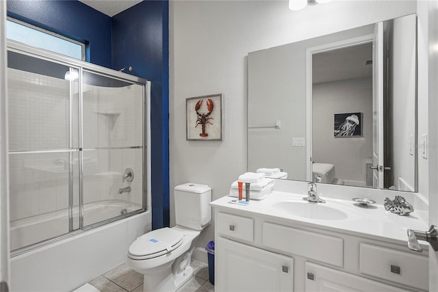 full bathroom with combined bath / shower with glass door, vanity, tile floors, and toilet