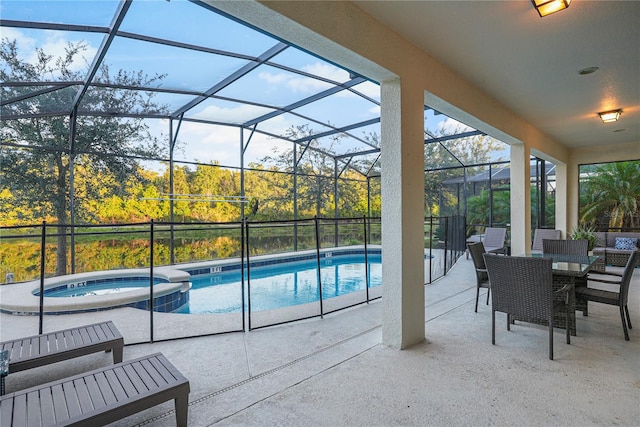 view of pool featuring a patio area, an in ground hot tub, and glass enclosure