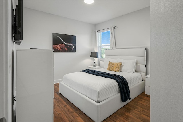 bedroom with dark hardwood / wood-style floors