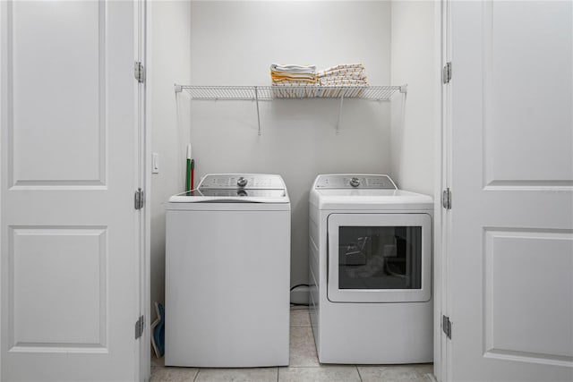 laundry area with separate washer and dryer and light tile floors