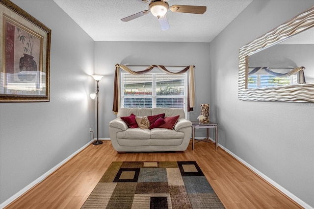 sitting room featuring ceiling fan, a healthy amount of sunlight, and light hardwood / wood-style flooring