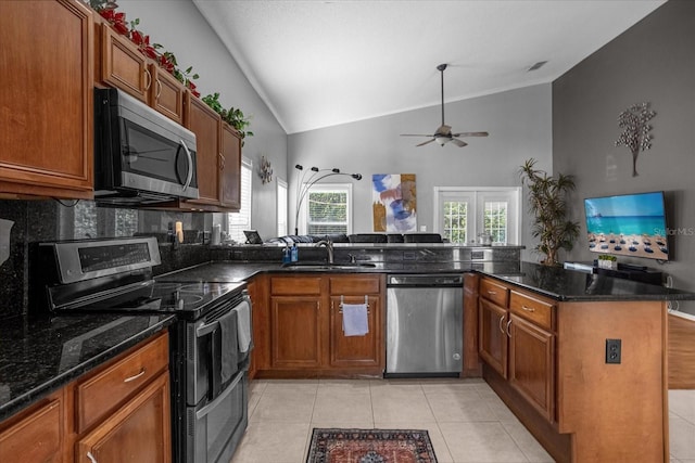 kitchen with appliances with stainless steel finishes, kitchen peninsula, lofted ceiling, and ceiling fan