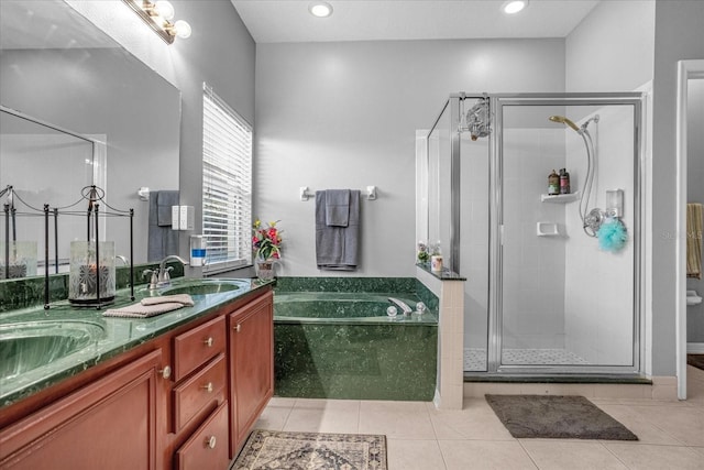 bathroom with double sink vanity, tile floors, and independent shower and bath