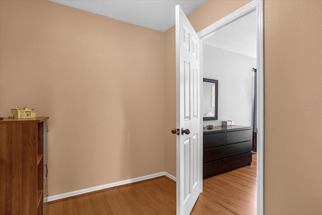 hall featuring a textured ceiling and light wood-type flooring