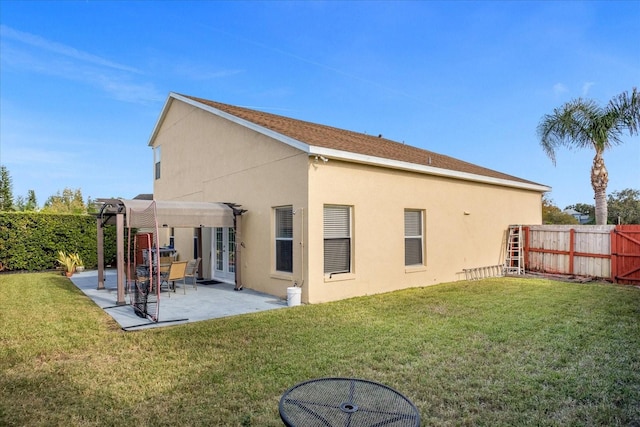 rear view of property with a yard and a patio