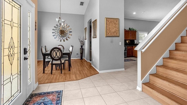 entryway featuring light hardwood / wood-style floors, a notable chandelier, and vaulted ceiling