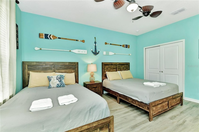 bedroom featuring ceiling fan, a closet, and light hardwood / wood-style flooring