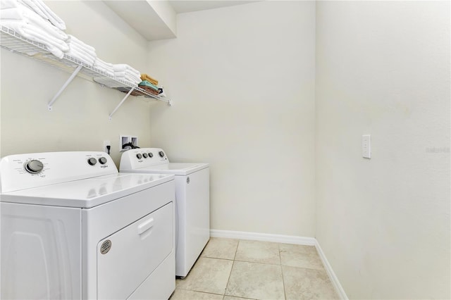 washroom featuring hookup for a washing machine, light tile flooring, and washing machine and dryer