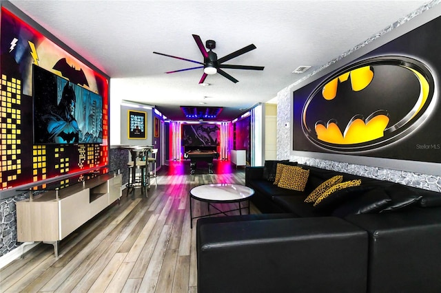 living room featuring a textured ceiling, ceiling fan, and hardwood / wood-style flooring