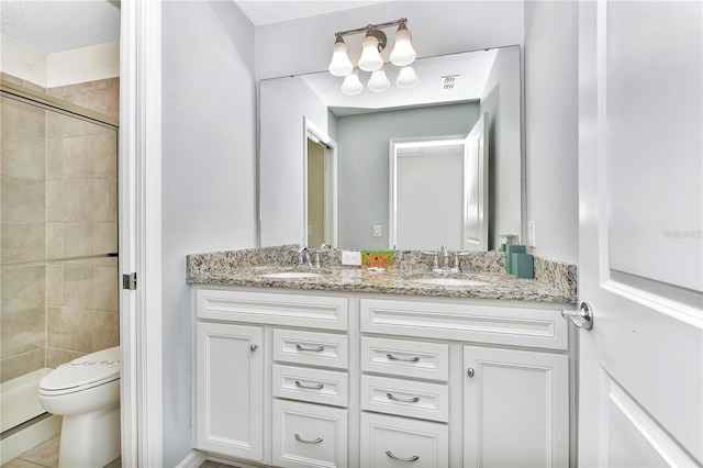 bathroom with a shower with shower door, tile floors, a textured ceiling, toilet, and double vanity