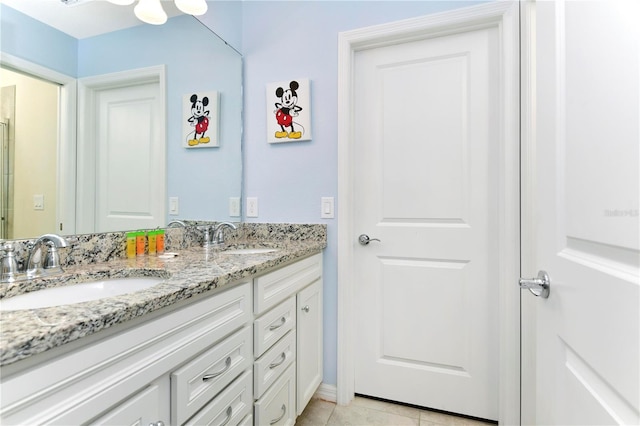 bathroom with oversized vanity, tile flooring, and dual sinks