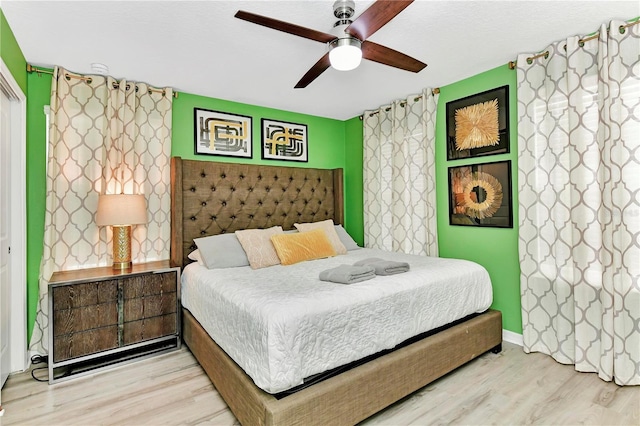 bedroom with ceiling fan and light hardwood / wood-style flooring