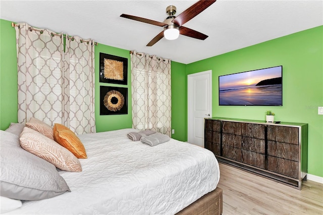 bedroom with light hardwood / wood-style floors and ceiling fan