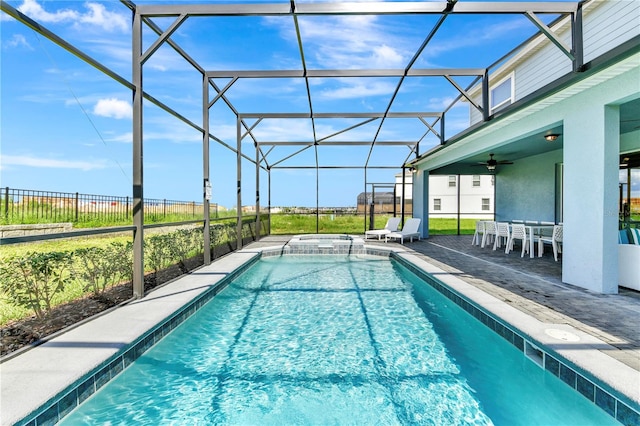 view of swimming pool with glass enclosure, ceiling fan, and a patio area