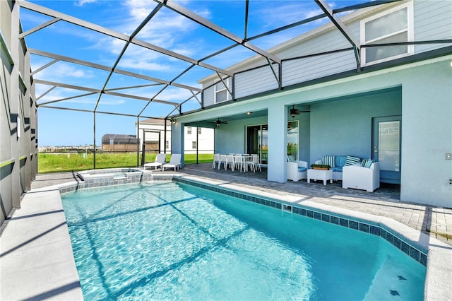 view of swimming pool with ceiling fan, an in ground hot tub, glass enclosure, and a patio