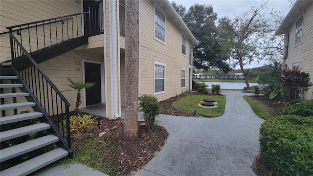 view of property exterior featuring a balcony, a patio, and a water view