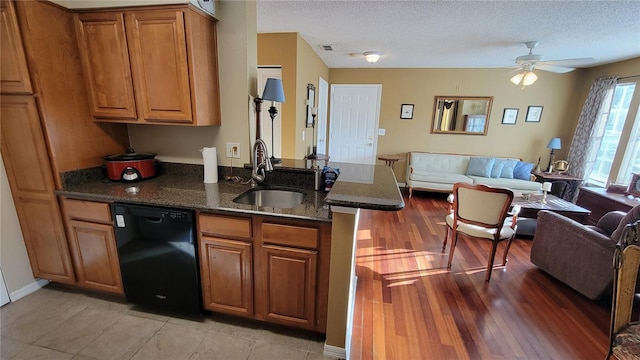 kitchen with light tile flooring, black dishwasher, ceiling fan, dark stone countertops, and sink