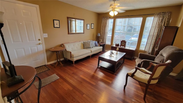 living room with a healthy amount of sunlight, ceiling fan, and dark hardwood / wood-style flooring