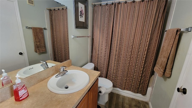 bathroom with toilet and vanity with extensive cabinet space