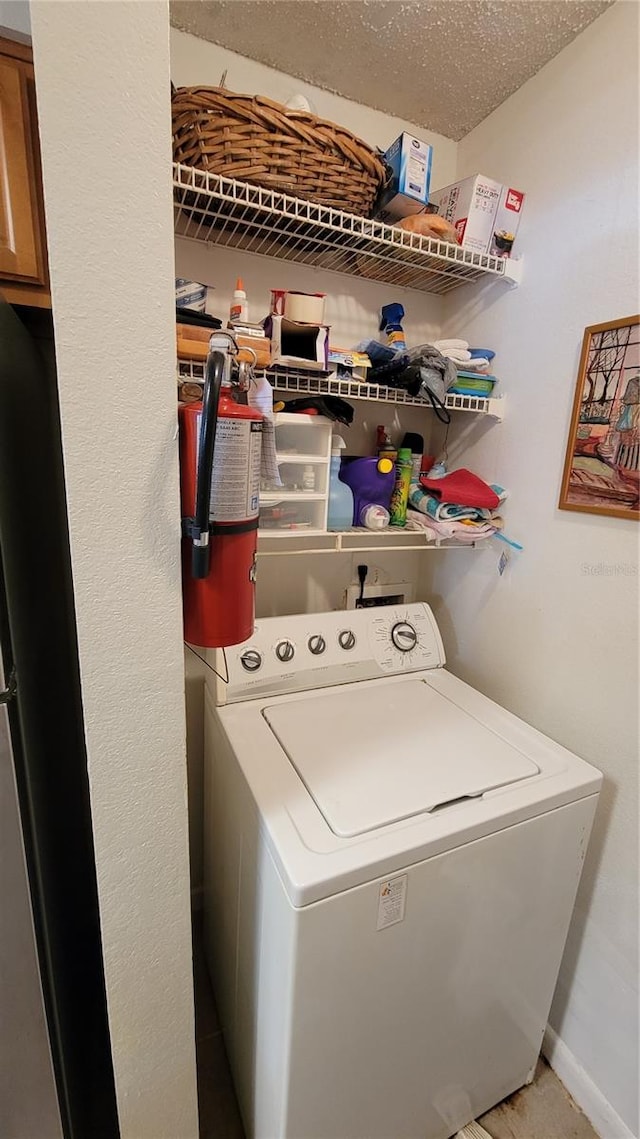 washroom with a textured ceiling and washer / dryer