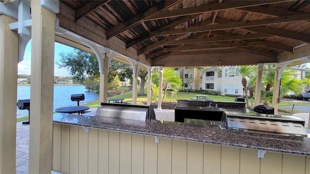 view of patio / terrace with a gazebo, area for grilling, and a water view