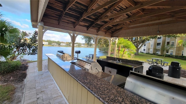 view of patio with a water view and area for grilling