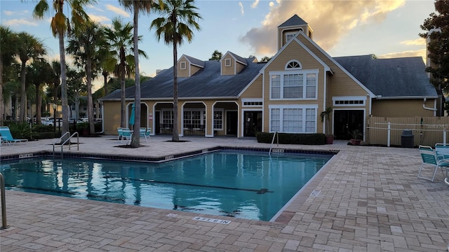 pool at dusk featuring a patio area