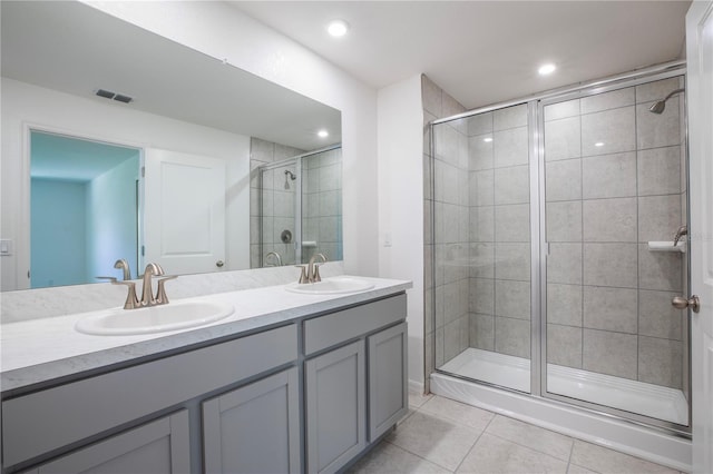 bathroom featuring tile patterned flooring, vanity, and walk in shower