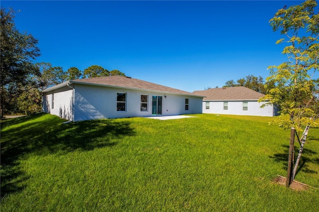 back of property featuring a lawn and a patio area